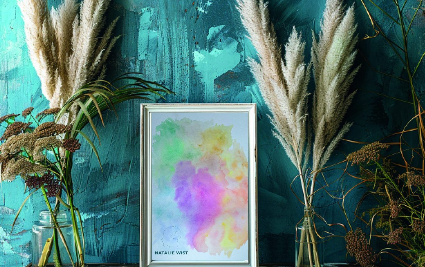 Rahmen mit buntem Aquarell Bild auf einem Hintergrund aus grün-blauer Wand, umgeben von Trockenblumen.